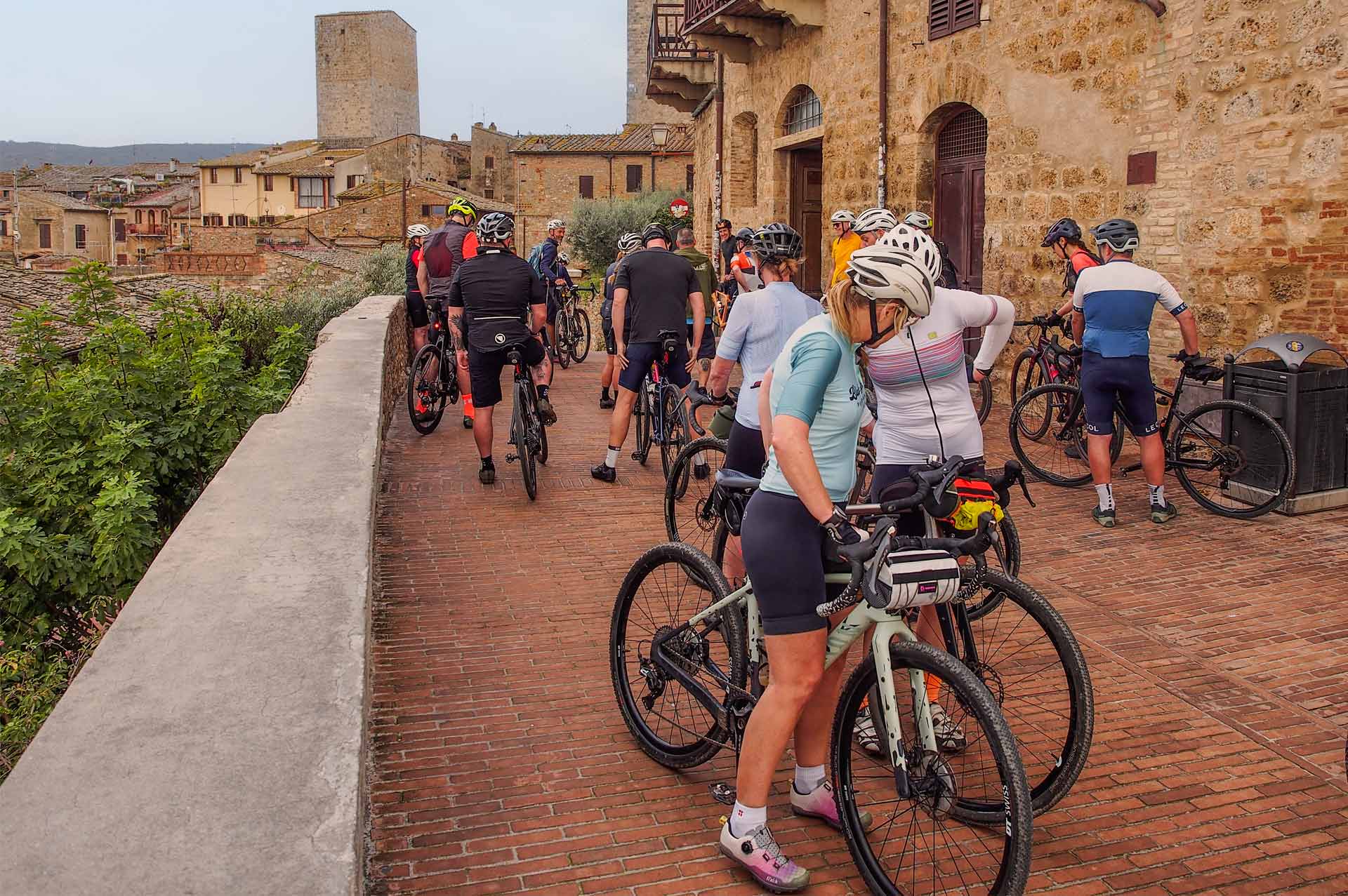 Gruppo di ciclisti in bici da strada durante un tour nel centro storico del Chianti, Toscana