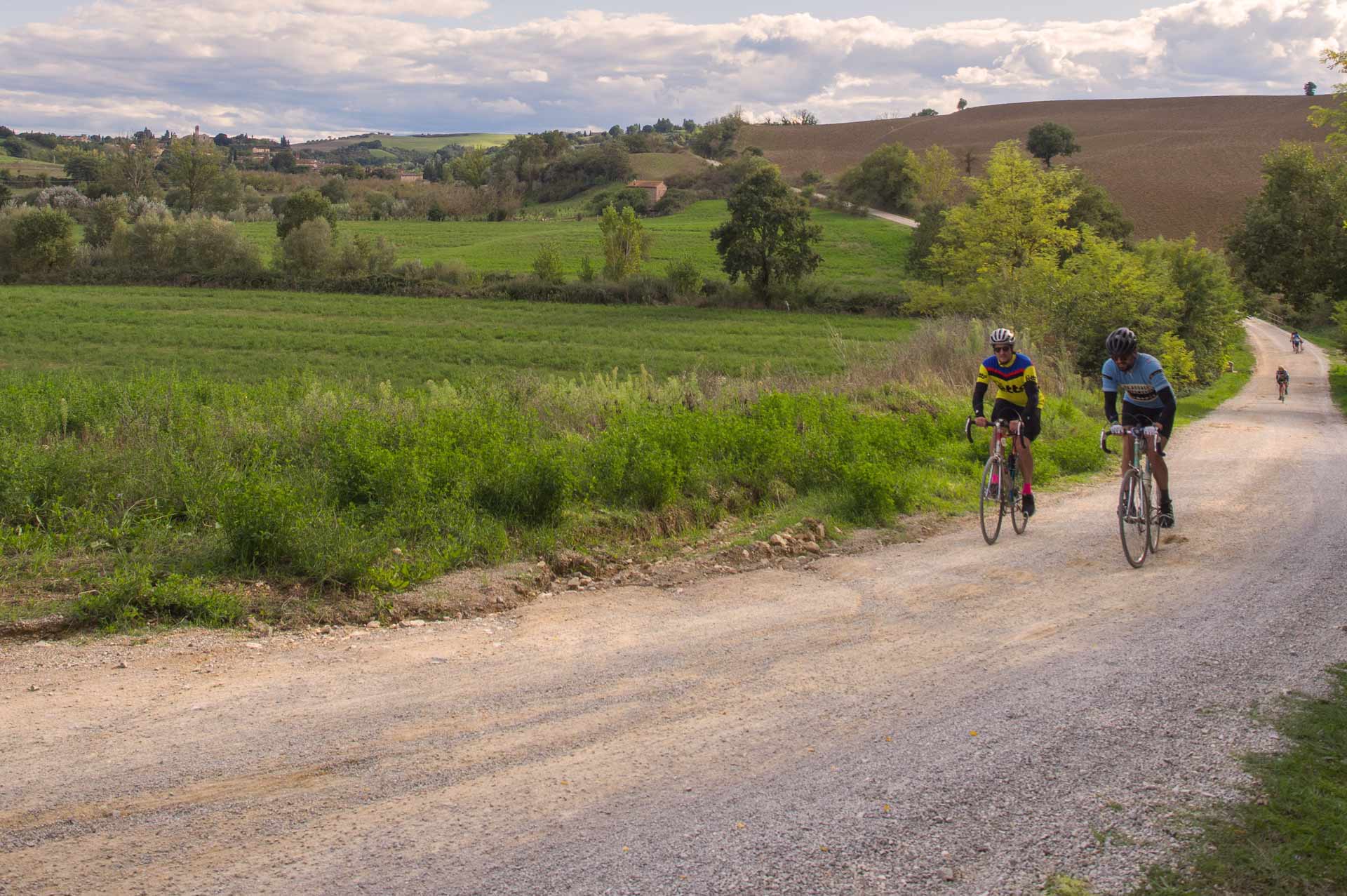 Ciclista su una strada bianca panoramica nelle Crete Senesi vicino a Siena