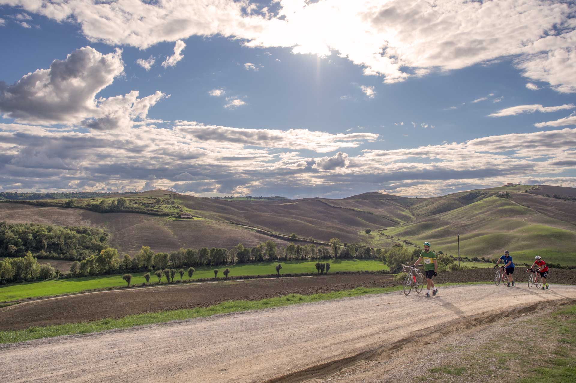 Ciclista illuminato dal sole su strada sterrata al tramonto