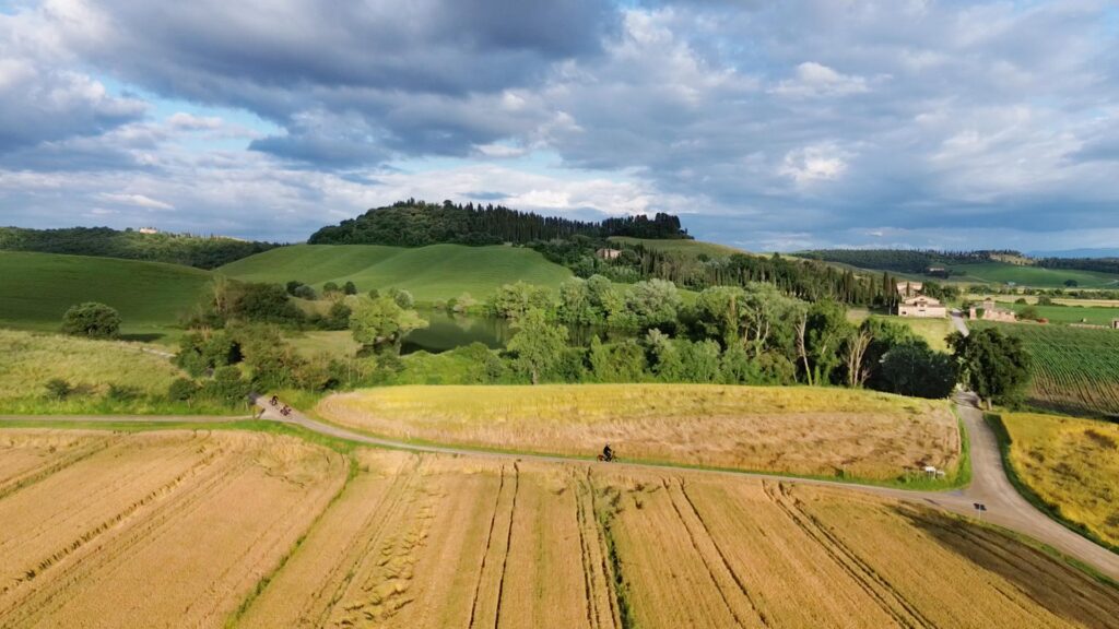 Tre ciclisti percorrono le strade bianche della Toscana durante il tour in bici dell’Eroica.